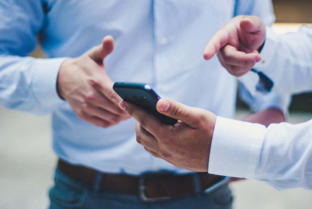 close shot of two men discussing something on a cell phone